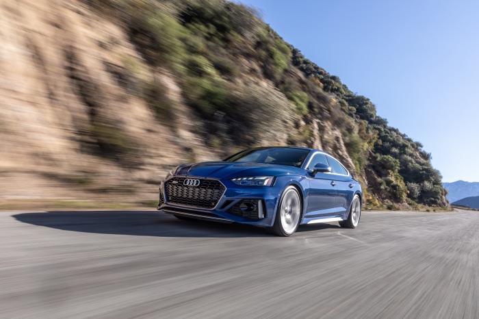 Blue Audi RS5 driving on a mountain road