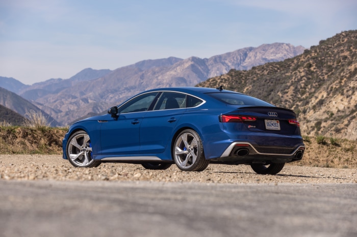 Blue Audi RS5 parked on a dirt road with mountains