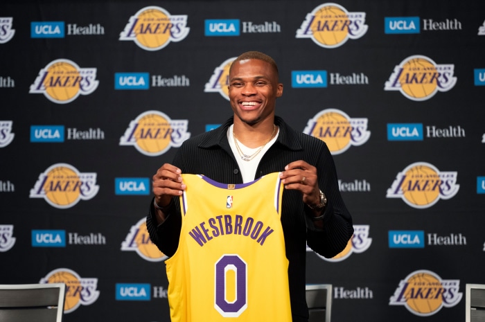 Russell Westbrook holding Los Angeles Lakers jersey