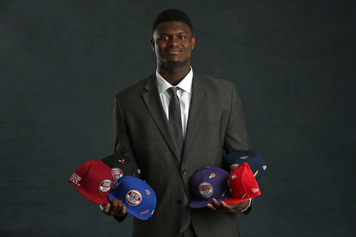Zion Williamson holding NBA team hats