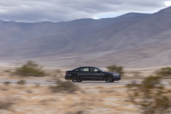 Audi A8 driving through a desert landscape