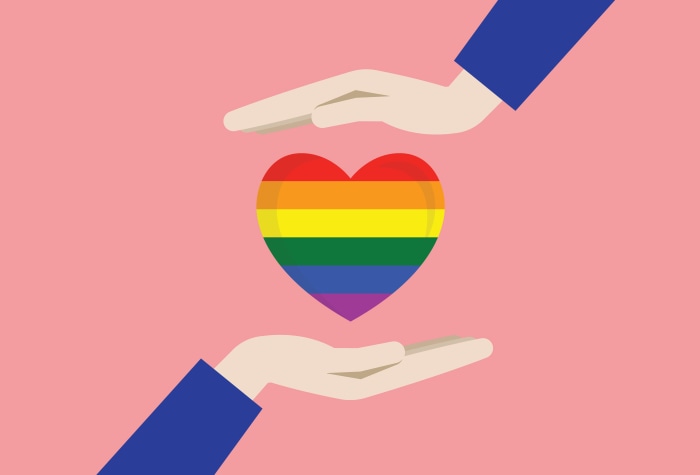 LGBT rainbow heart held by hands