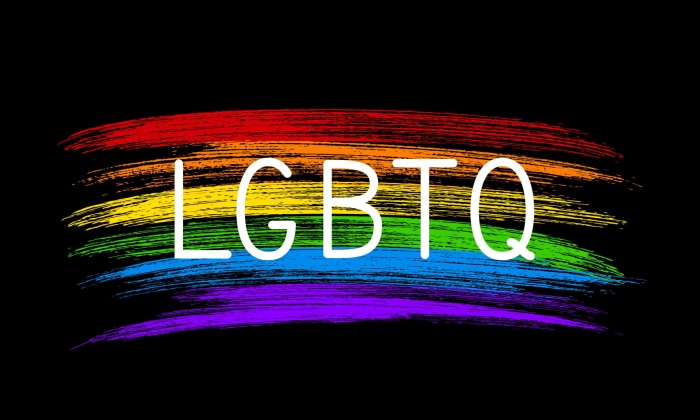LGBTQ text on a rainbow brush stroke background