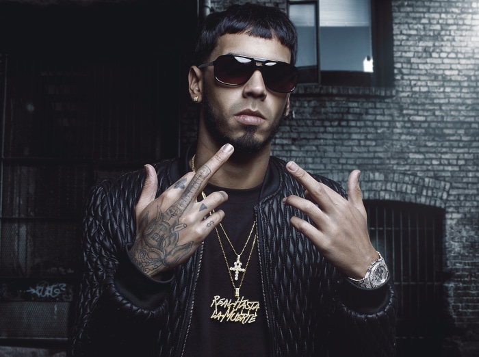 Anuel AA wearing sunglasses and jewelry