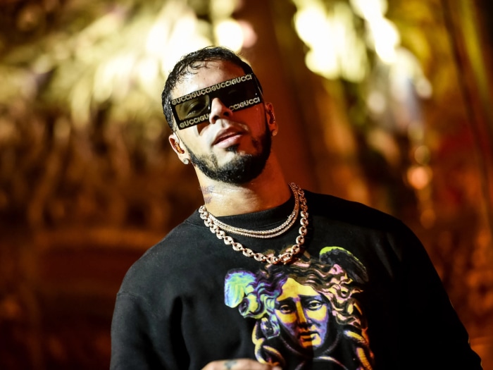 Anuel AA wearing Gucci sunglasses and a chain