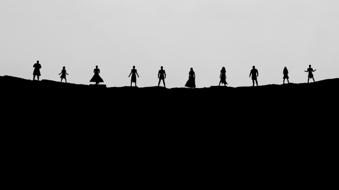 Silhouettes of the Eternals standing on a ridge