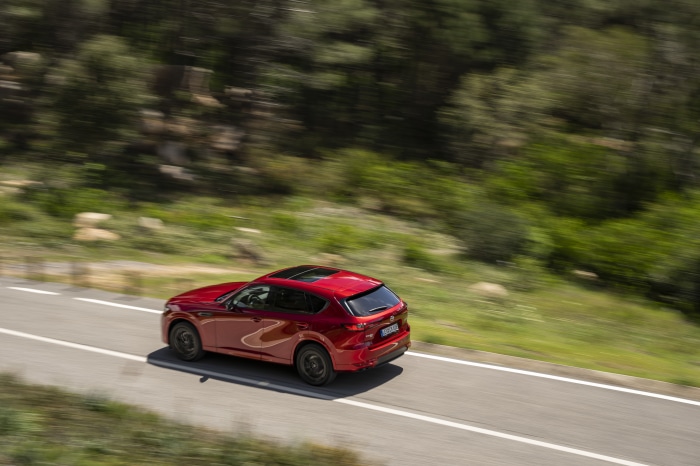 Red Mazda CX-60 driving on a road