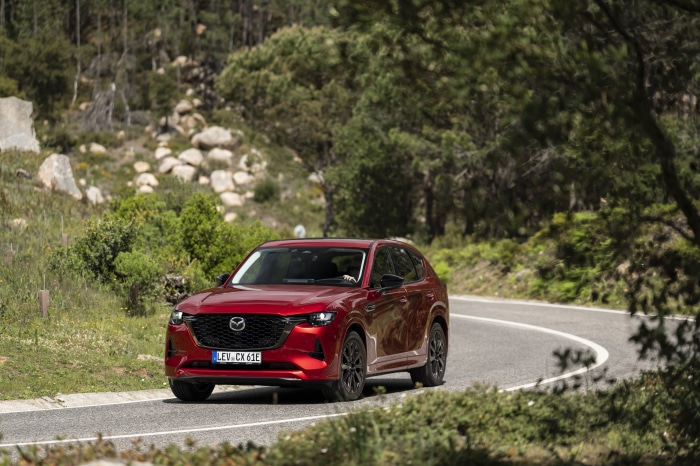 Red Mazda CX-60 driving on a winding road