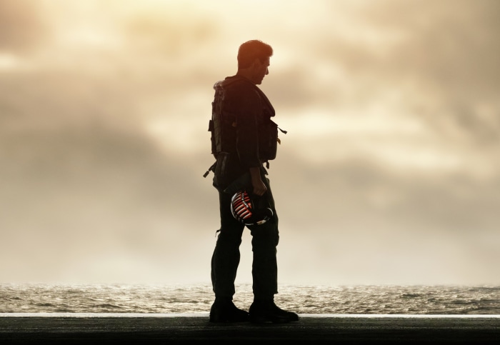 Maverick from Top Gun: Maverick holding a helmet