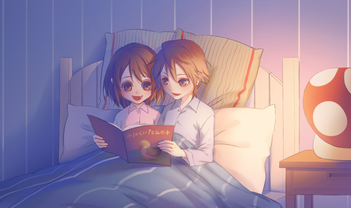 Two children reading a book in bed