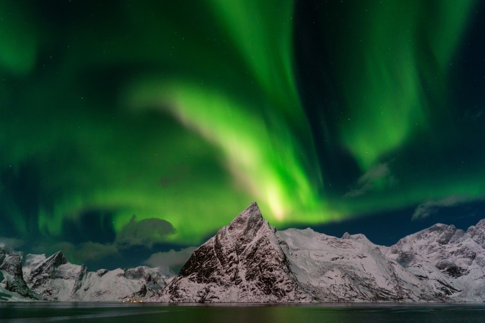 Aurora Borealis over snow-covered mountains in Norway