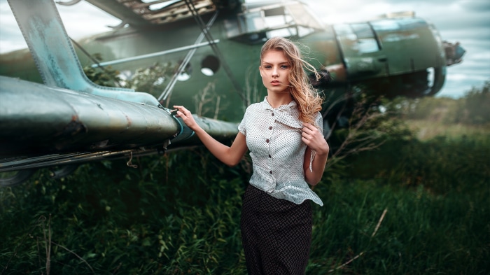 Woman posing near an abandoned airplane