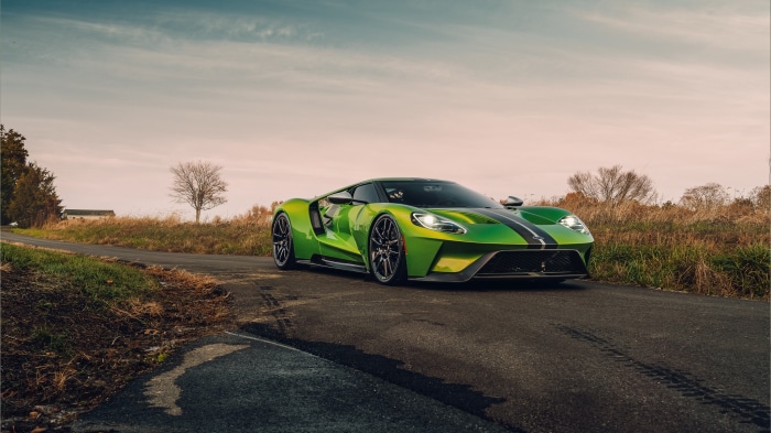 Green Ford GT driving on a rural road