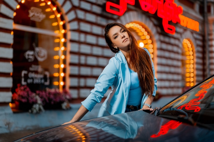 Gulmira Zubanova posing near a car at night