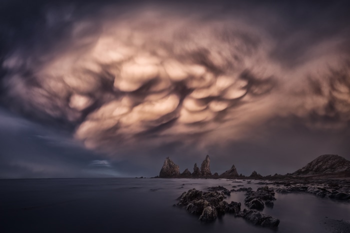 Mammatus clouds over rocky coastline