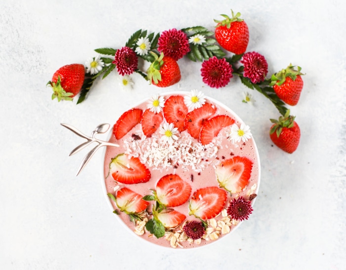 Strawberry smoothie bowl with flowers and strawberries
