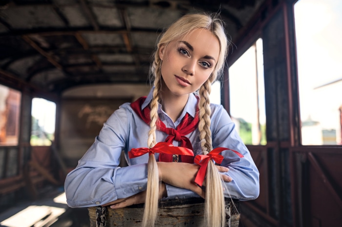 Young woman with blonde braids and red scarf