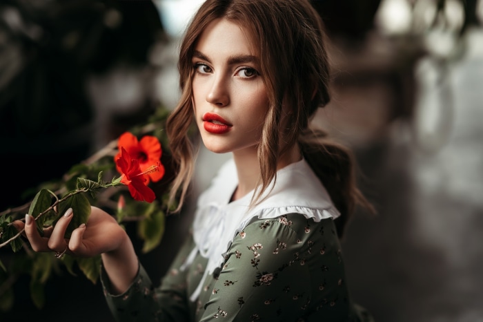 Woman with red lipstick and hibiscus flower