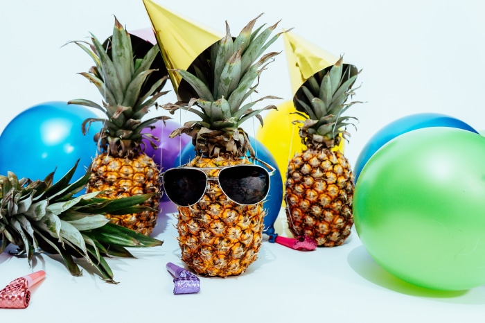 Pineapples wearing sunglasses at a party