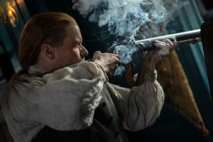 Jamie Fraser firing a rifle