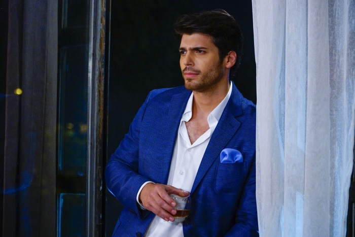 Man in blue suit holding a drink