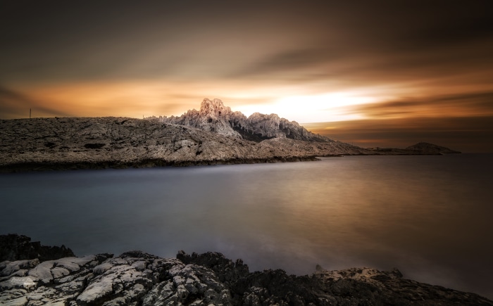 Rocky coastline at dawn with orange sky