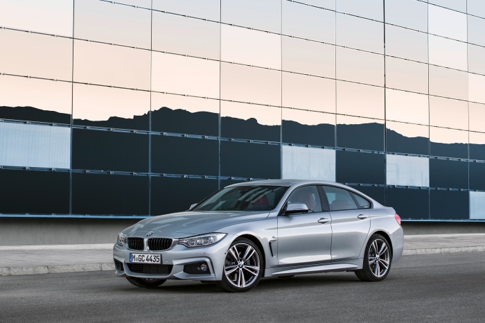 Silver BMW 4 Series Gran Coupé parked in front of a modern building