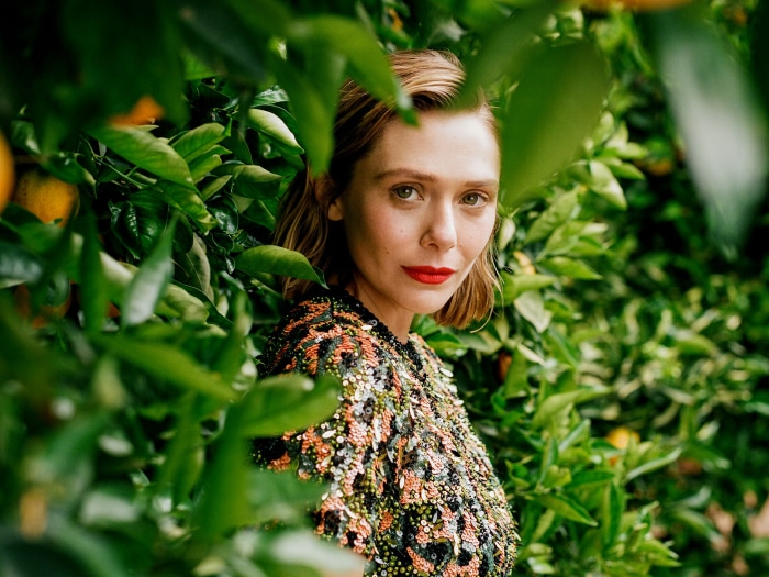 Elizabeth Olsen in a sequined top among orange trees