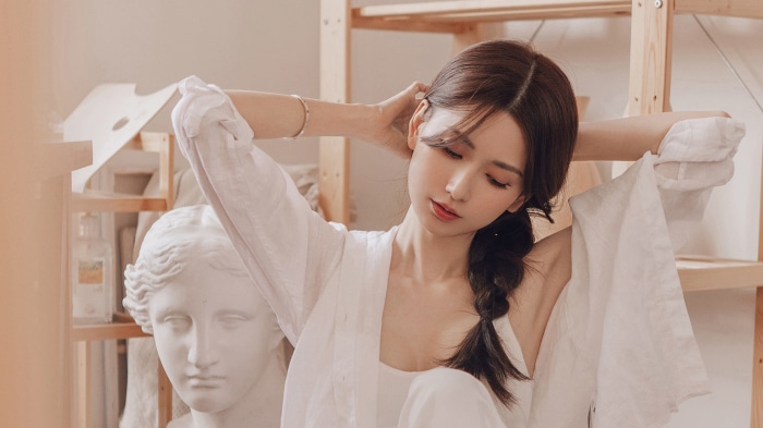 Asian Woman with Braided Hair and Sculpture