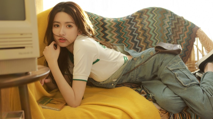 Asian woman in casual clothes lounging on a couch