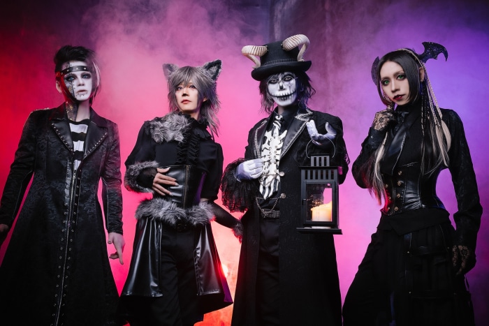 Four individuals in gothic costumes posing