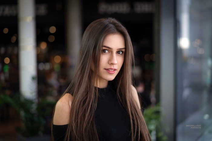 Woman with long brown hair wearing a black top
