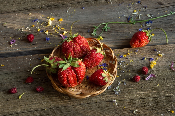 Strawberries in a basket on a wooden table