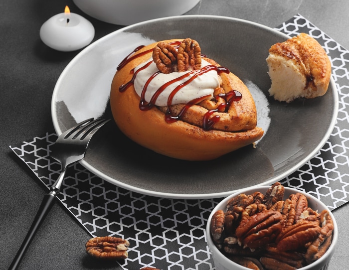 Cinnamon roll with pecans and cream 4K