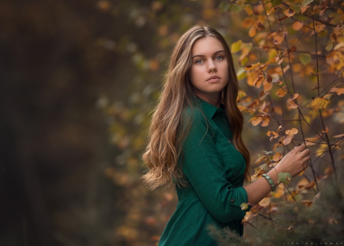 Woman in green dress in autumn forest