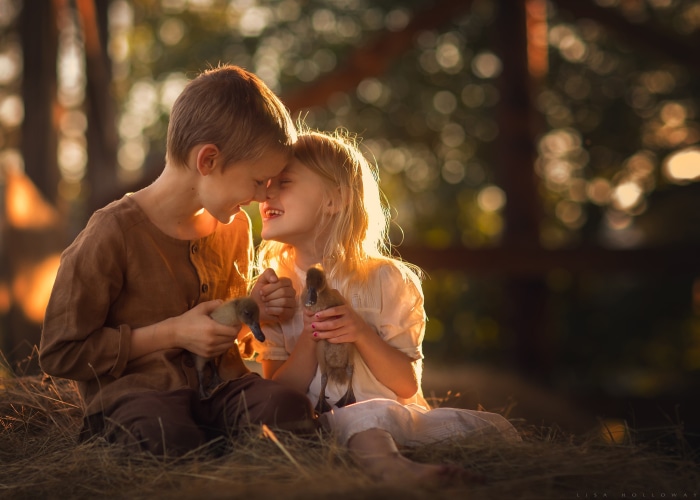 Children with ducklings in a sunlit field