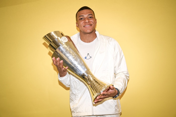Kylian Mbappé holding a trophy