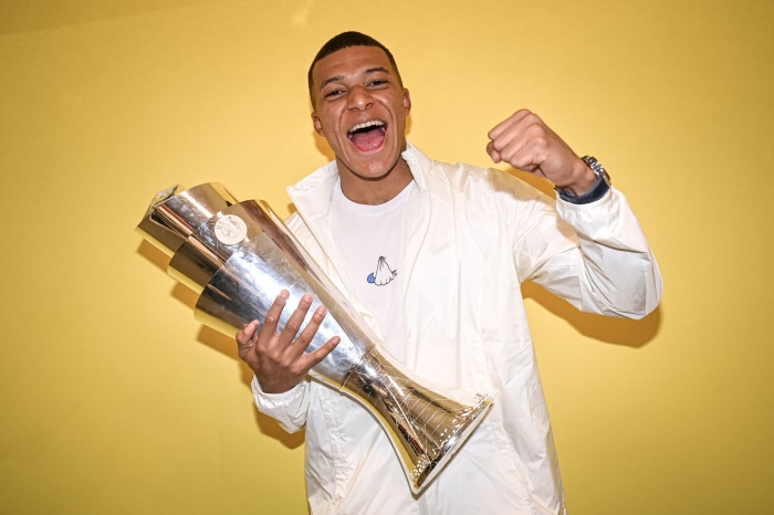 Kylian Mbappé holding a trophy