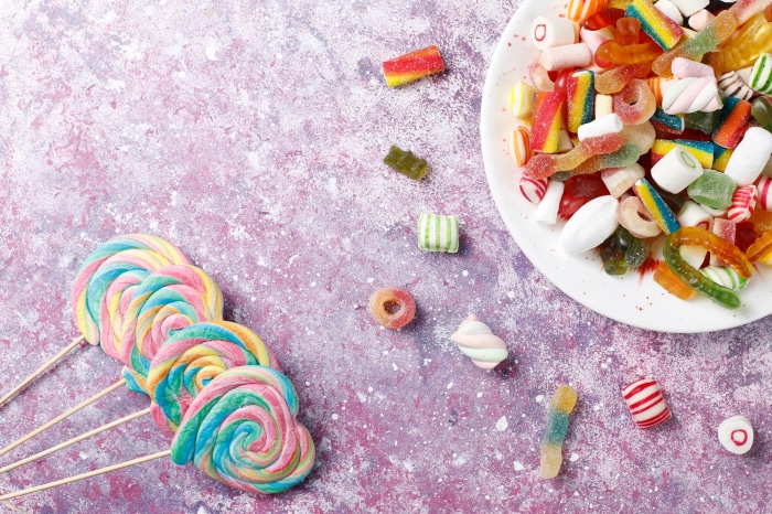 Colorful lollipops and candies on a textured surface