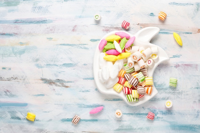 Assortment of colorful candies on a white apple-shaped plate