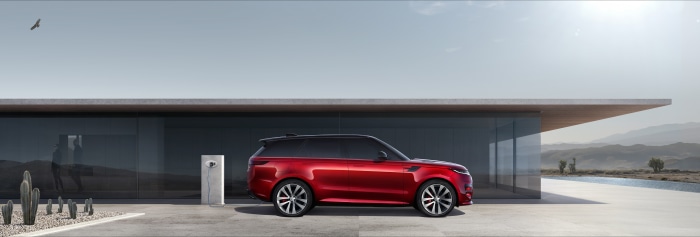 Red Range Rover Sport PHEV charging at modern house