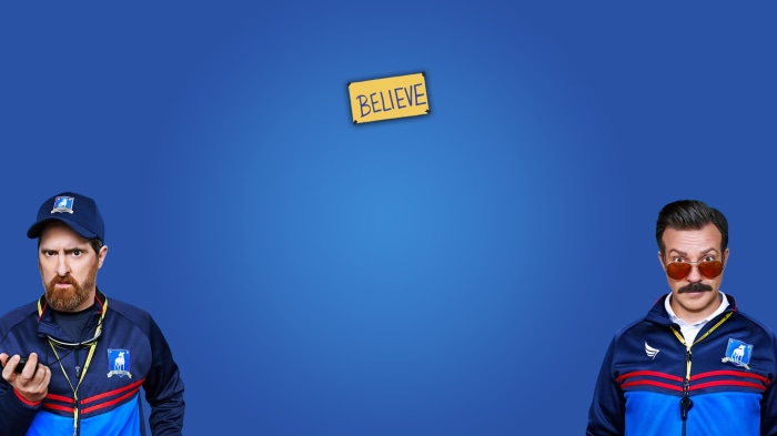 Ted Lasso and Coach Beard from Ted Lasso with Believe sign