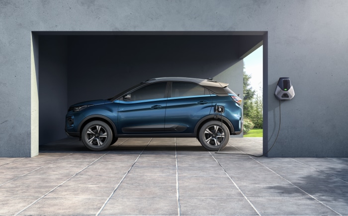 Blue Tata Nexon EV charging in a garage
