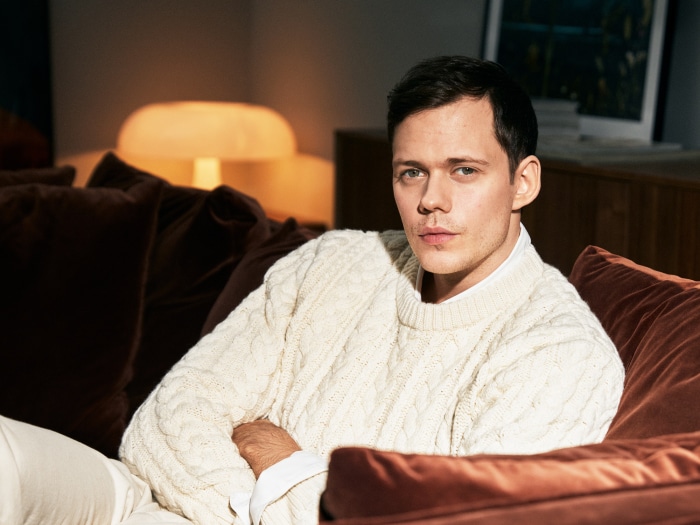 Bill Skarsgård sitting on a couch