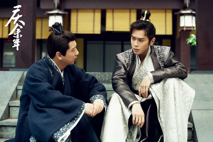 Two men in traditional Chinese clothing sitting on steps