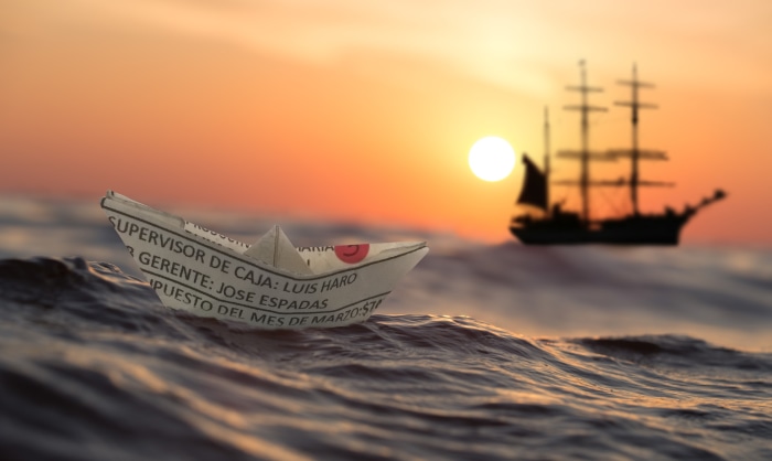 Paper boat and ship at sunset