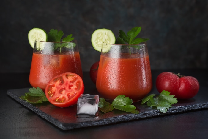 Two glasses of tomato juice with garnishes