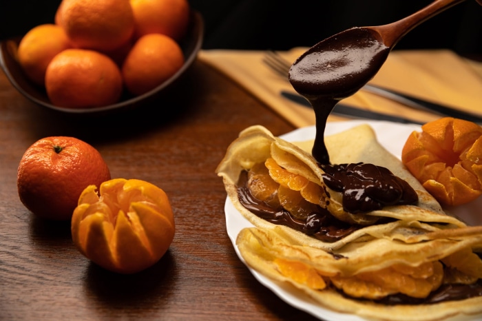 Chocolate and tangerine crepes with a bowl of tangerines