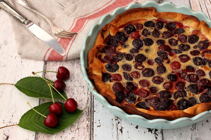 Cherry pie in a blue dish with fresh cherries