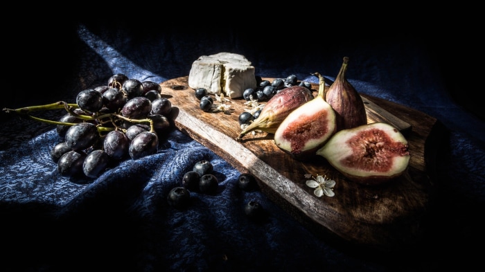 Still life with cheese, grapes, figs, and blueberries